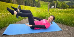 Frau macht Pilates Übung mit dem Pilatesring