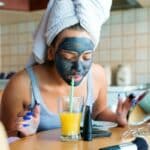 Frau mit Gesichtsmaske am Tisch sitzend / Morgenroutine bei Fibromyalgie