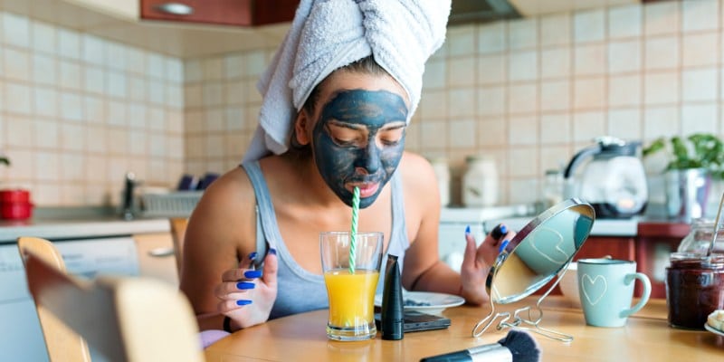 Frau mit Gesichtsmaske am Tisch sitzend / Morgenroutine bei Fibromyalgie