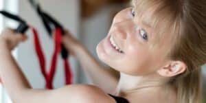 schwangere Frau macht eine Übung am TRX Suspension Trainer