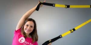 Frau macht Stretching Übung am TRX