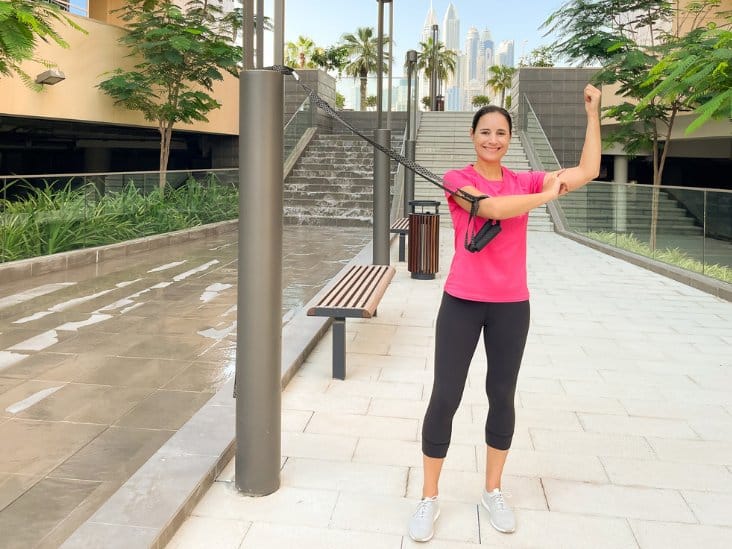 Frau macht eine TRX Armübung